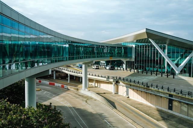 A transparent airport with glass walkways and a glass building, offering convenient airport transfer services and a luxurious limousine service in Austin.
