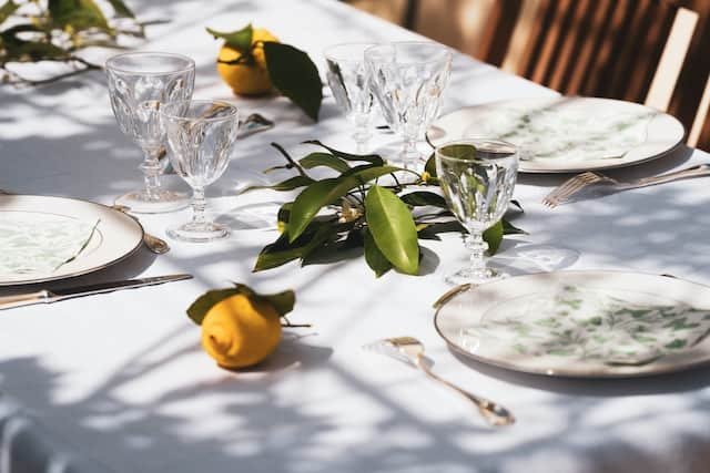 A table setting with lemons and greenery, perfect for a refreshing summertime gathering.