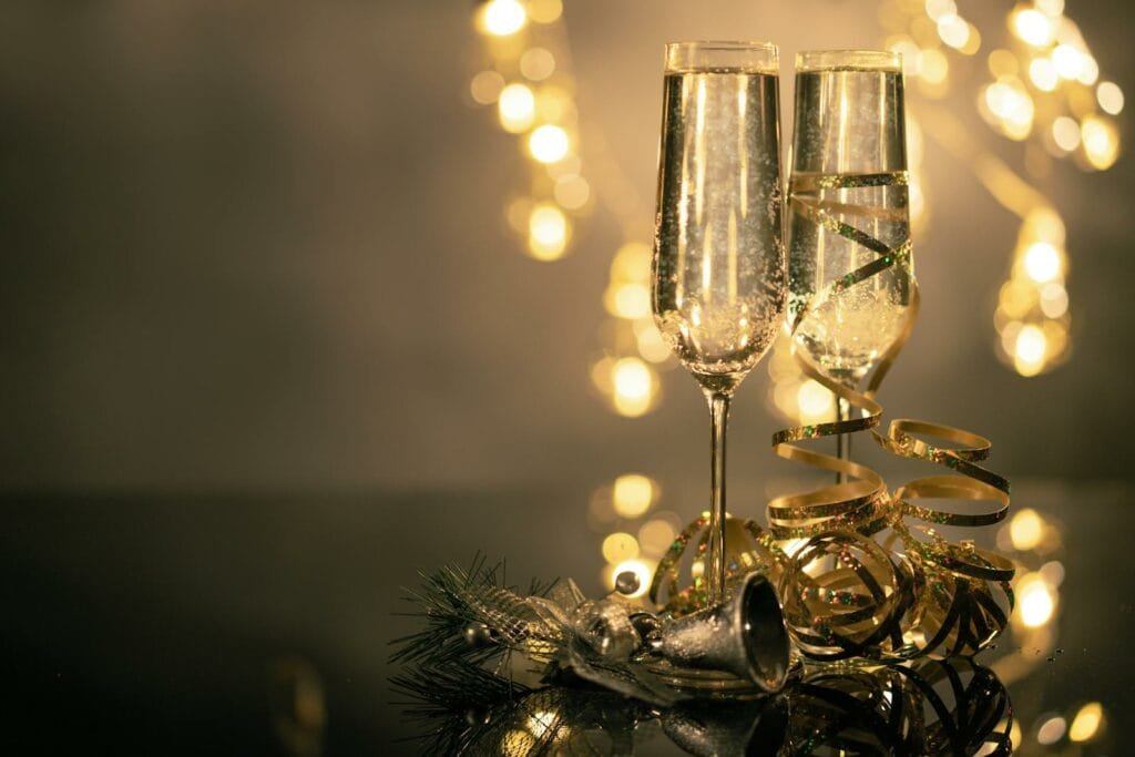 A table adorned with lights and decorations features two champagne flutes, offering a luxurious ambiance perfect for celebrating special occasions or enjoying a romantic evening.