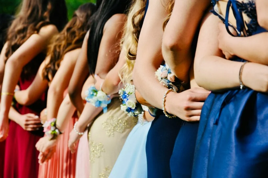 A group of girls in formal dresses standing in a line, ready to embark on their memorable limousine journey.