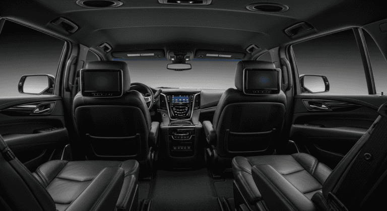 Interior view of a high-end SUV showcasing leather seats, dual screens, and premium wood accents.
